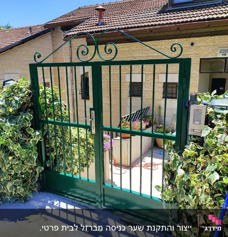 שער מתכת ירוק עם עיטורים, מוקף בצמחייה